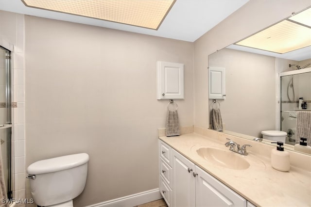 bathroom featuring an enclosed shower, toilet, and vanity