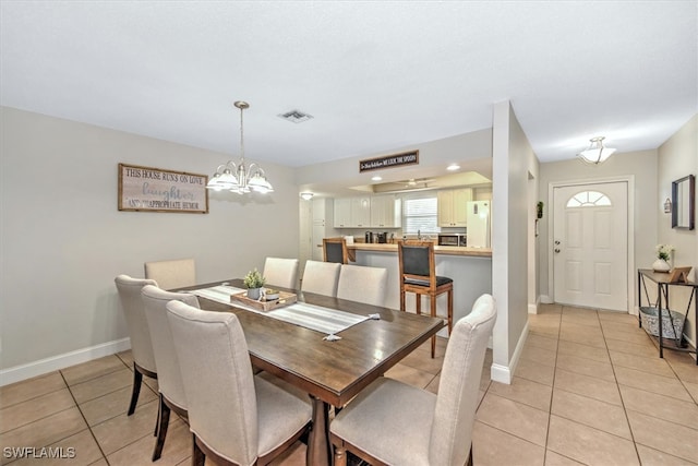 tiled dining area featuring a chandelier