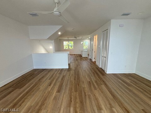 unfurnished living room featuring visible vents, baseboards, ceiling fan, and wood finished floors