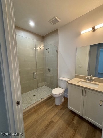 full bath featuring visible vents, toilet, a shower stall, vanity, and wood finished floors