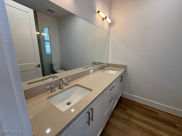 bathroom with toilet, a sink, and baseboards