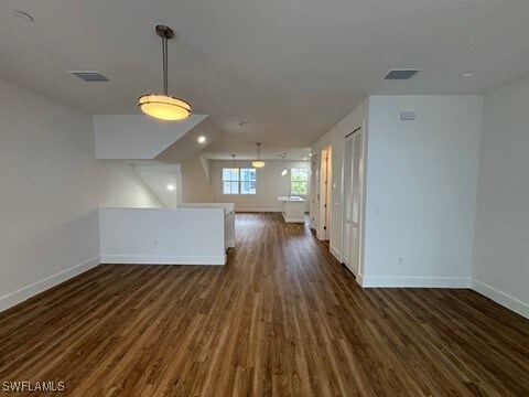 interior space featuring vaulted ceiling and dark hardwood / wood-style flooring