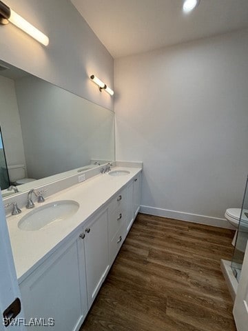 bathroom featuring vanity, hardwood / wood-style floors, walk in shower, and toilet