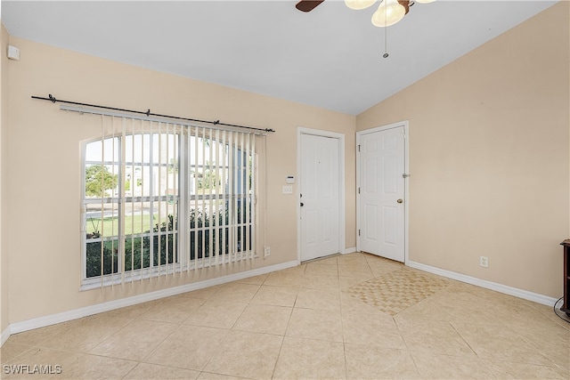 tiled spare room with lofted ceiling and ceiling fan