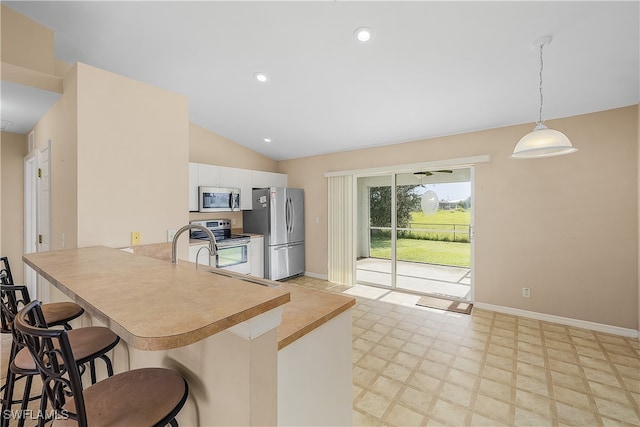 kitchen featuring a kitchen breakfast bar, hanging light fixtures, stainless steel appliances, kitchen peninsula, and lofted ceiling