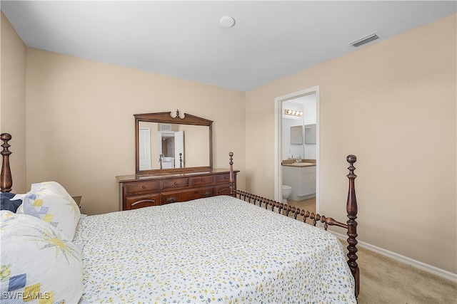 bedroom with light carpet and ensuite bathroom