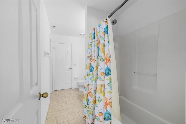 bathroom featuring toilet and shower / bath combo