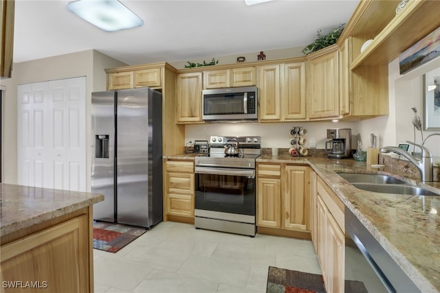 kitchen featuring light tile patterned floors, sink, light stone countertops, appliances with stainless steel finishes, and light brown cabinets