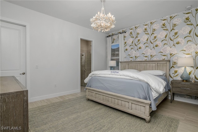 bedroom featuring connected bathroom and a chandelier