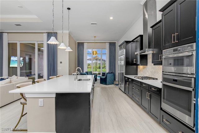 kitchen featuring backsplash, stainless steel appliances, a kitchen bar, sink, and a center island with sink