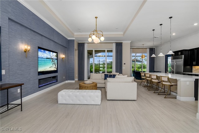 living room featuring sink, a raised ceiling, light tile patterned floors, and an inviting chandelier