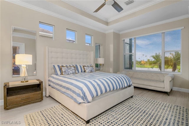 bedroom with light hardwood / wood-style flooring, ceiling fan, a raised ceiling, and crown molding