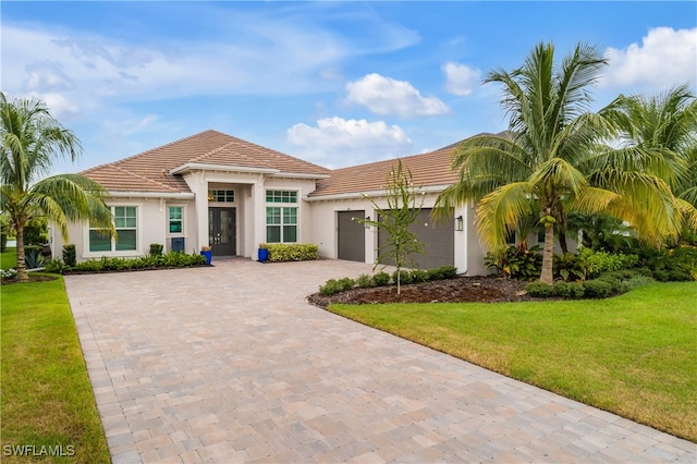 mediterranean / spanish-style home with a front yard and a garage