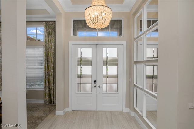 foyer featuring a notable chandelier, french doors, and ornamental molding