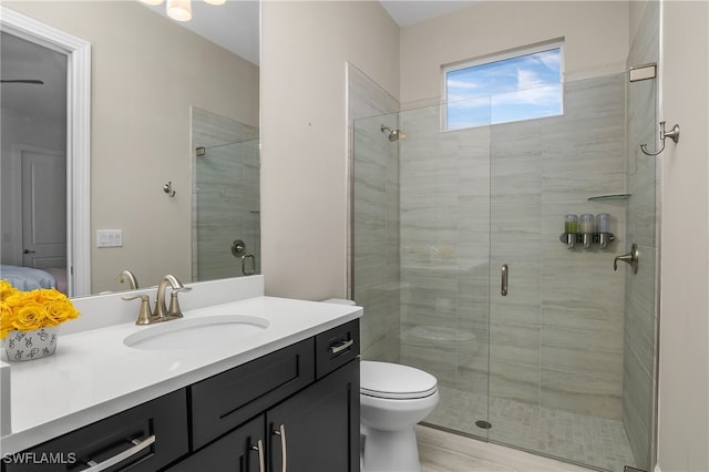 bathroom featuring toilet, walk in shower, and vanity