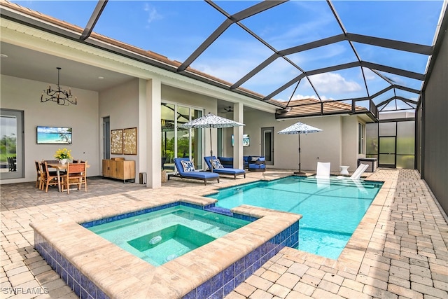 view of pool with glass enclosure, an in ground hot tub, a patio area, and an outdoor hangout area