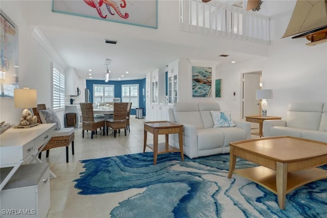 living area featuring light tile patterned floors, visible vents, ornamental molding, and recessed lighting