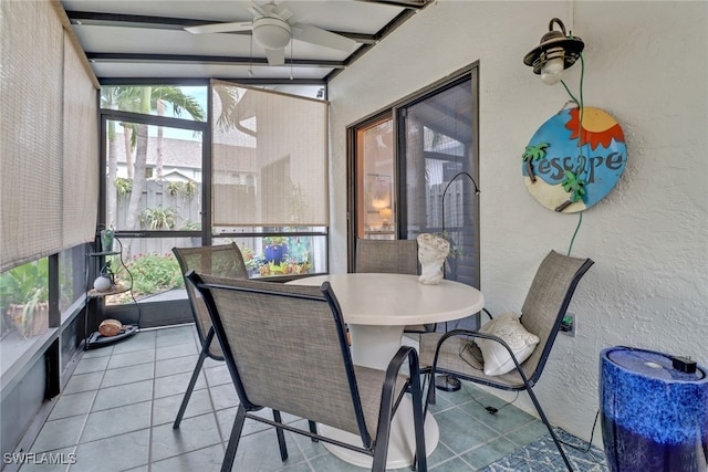 sunroom / solarium featuring beamed ceiling and a ceiling fan