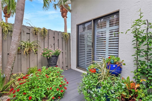 property entrance featuring stucco siding and fence