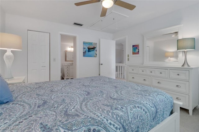 bedroom featuring visible vents, a ceiling fan, ensuite bath, carpet, and attic access