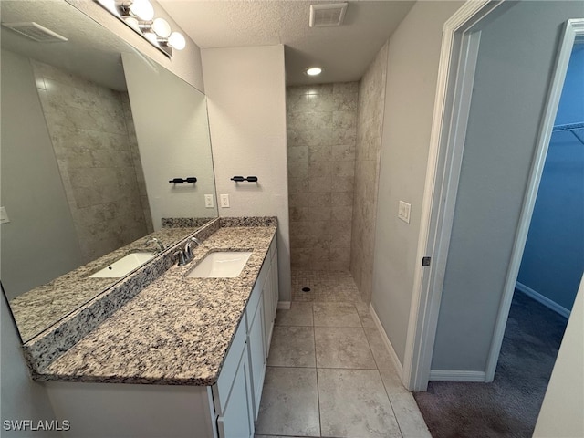 bathroom featuring a textured ceiling, vanity, and tile patterned floors