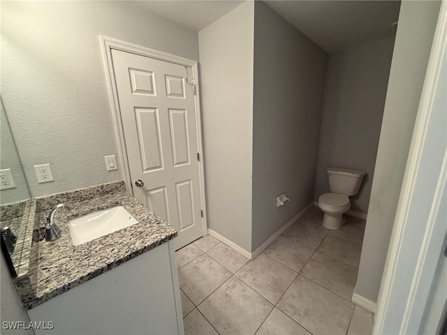 bathroom featuring tile patterned floors, vanity, and toilet