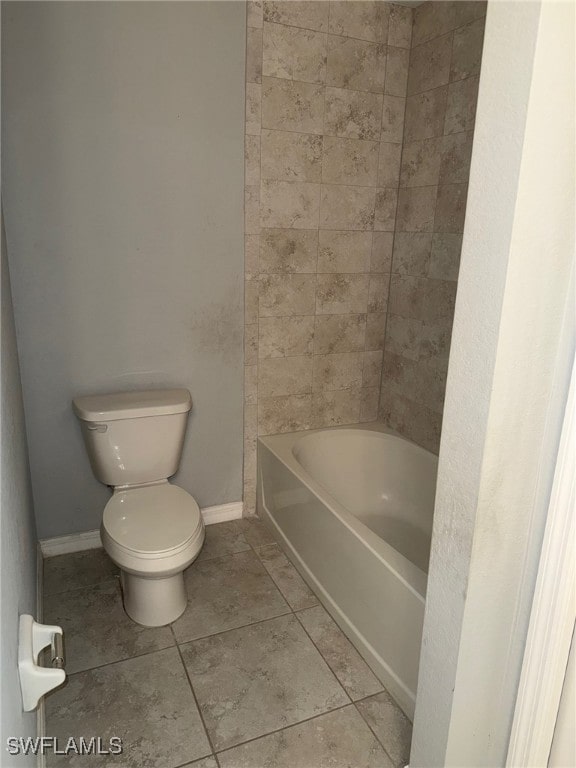 bathroom featuring tile patterned floors, toilet, and tiled shower / bath