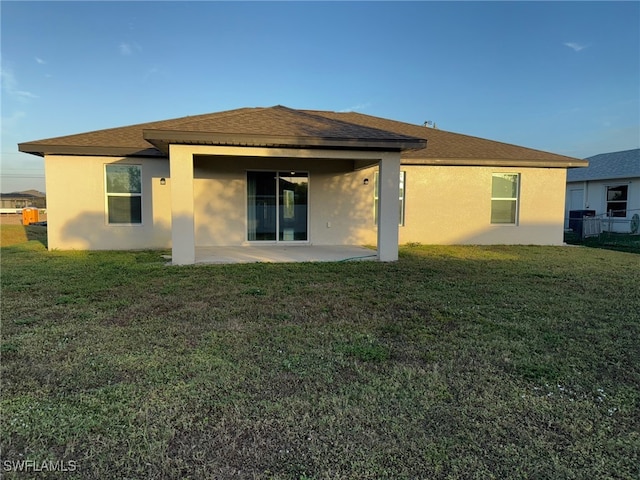 back of property featuring a lawn and a patio