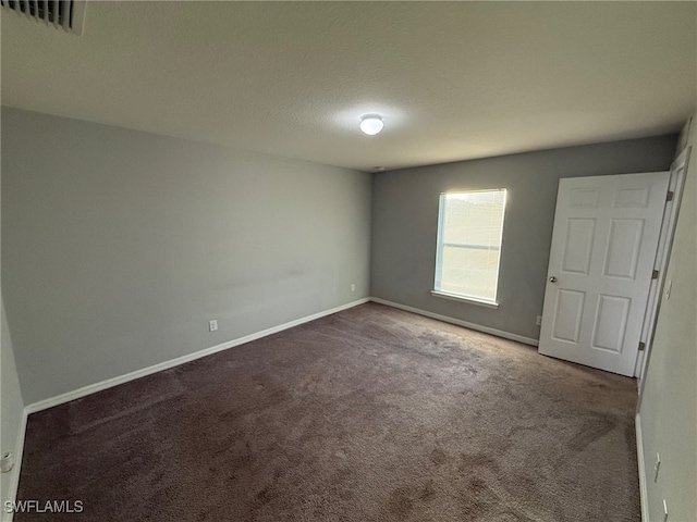 spare room featuring carpet and a textured ceiling