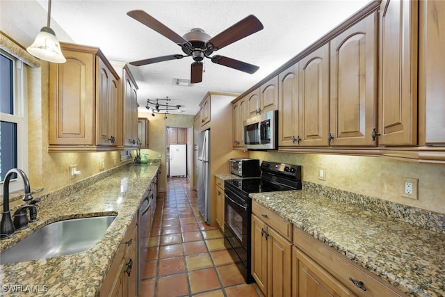 kitchen with stainless steel appliances, rail lighting, dark tile patterned flooring, sink, and ceiling fan