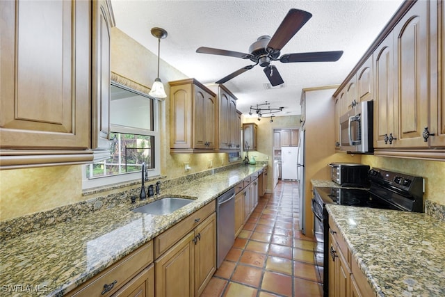 kitchen featuring rail lighting, tile patterned flooring, ceiling fan, stainless steel appliances, and pendant lighting