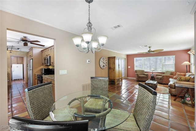 dining space with ceiling fan with notable chandelier, dark tile patterned floors, and ornamental molding