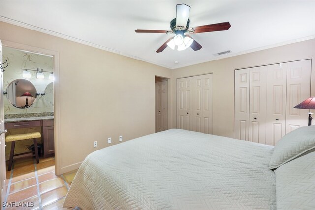 bedroom with ceiling fan, ornamental molding, multiple closets, ensuite bathroom, and light tile patterned flooring