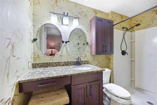 bathroom featuring vanity, walk in shower, and toilet