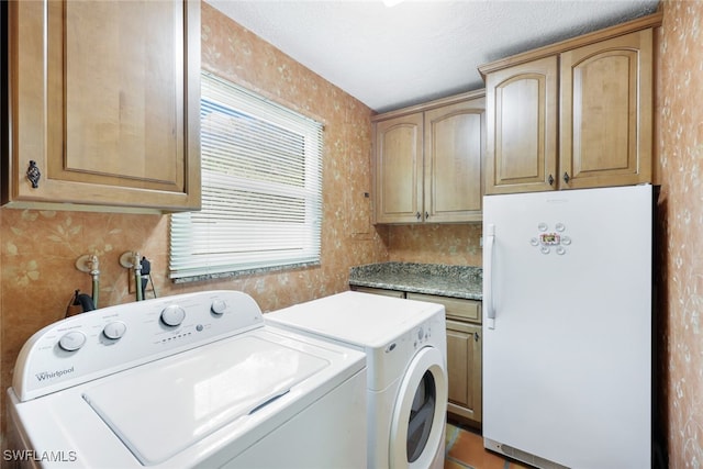 clothes washing area featuring independent washer and dryer and cabinets