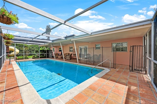 view of pool featuring glass enclosure and a patio area