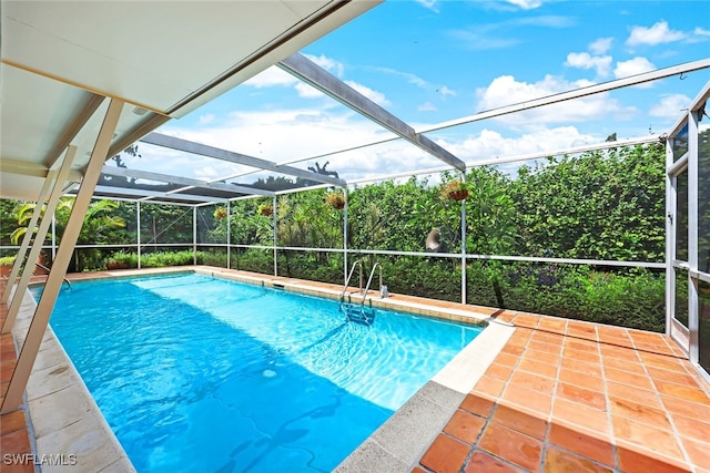 view of swimming pool featuring glass enclosure and a patio