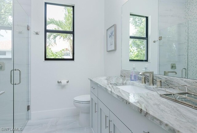 bathroom with walk in shower, vanity, toilet, and a wealth of natural light