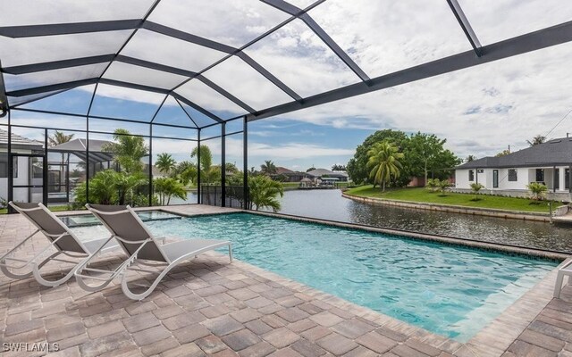 view of swimming pool with glass enclosure, a patio area, a water view, and a jacuzzi