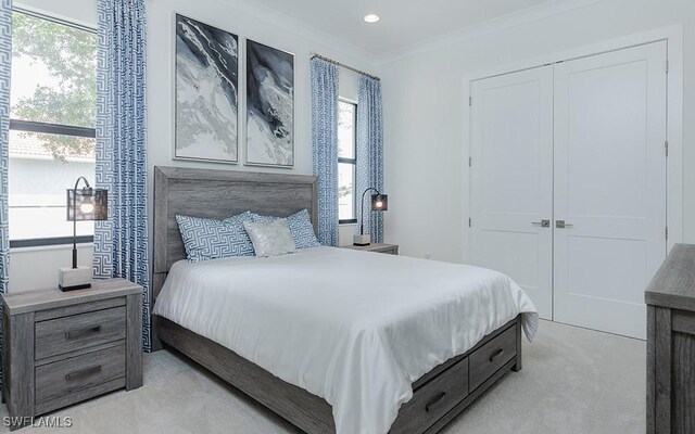 carpeted bedroom with multiple windows, crown molding, and a closet