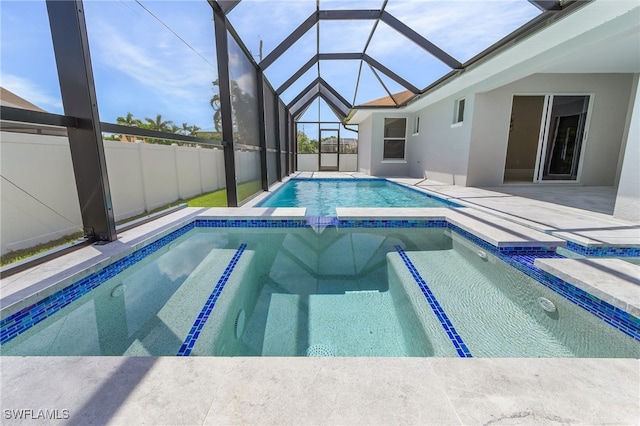 view of swimming pool with a lanai, a patio area, and an in ground hot tub