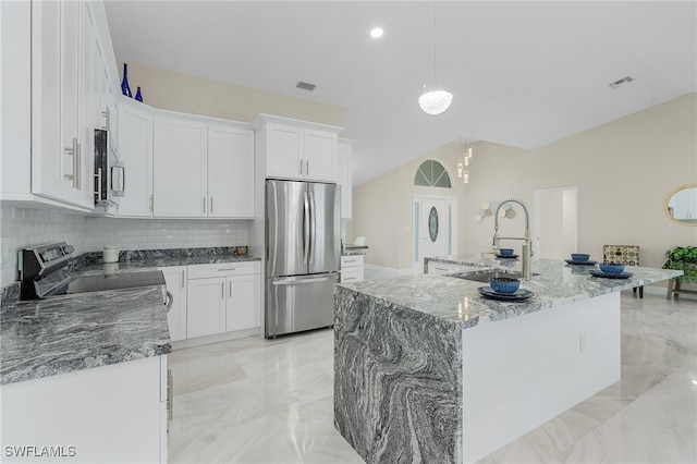 kitchen with white cabinetry, a kitchen island with sink, stainless steel appliances, decorative light fixtures, and decorative backsplash