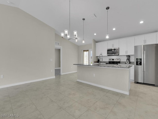 kitchen with light tile patterned flooring, appliances with stainless steel finishes, white cabinets, and lofted ceiling