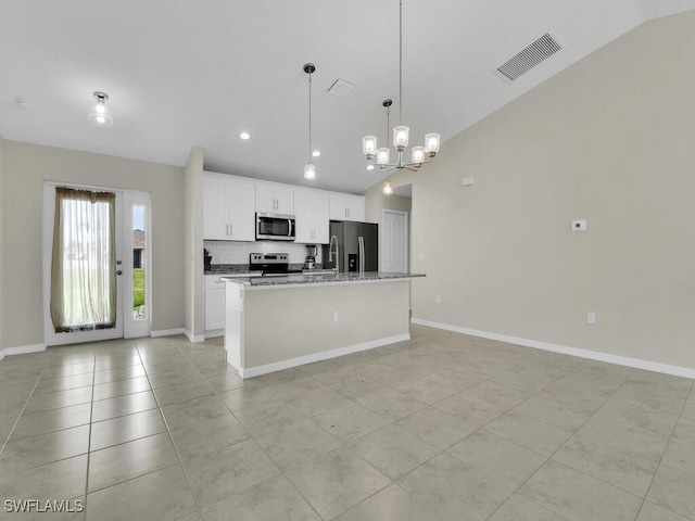 kitchen featuring stainless steel appliances, an inviting chandelier, lofted ceiling, white cabinets, and light tile patterned floors