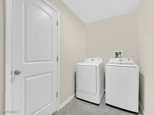 laundry area with washer and dryer and light tile patterned flooring