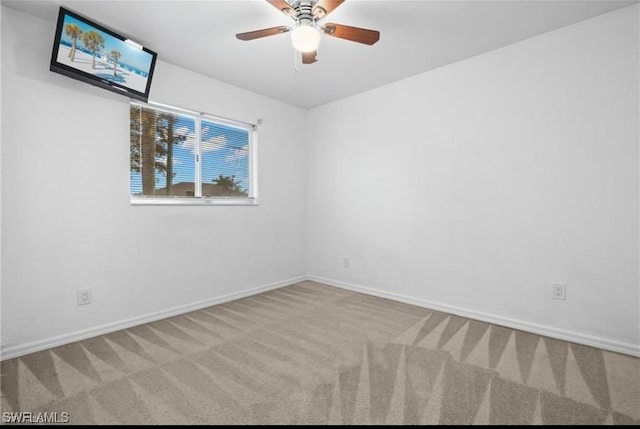 carpeted spare room featuring ceiling fan