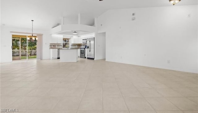 unfurnished living room featuring high vaulted ceiling, a notable chandelier, and light tile patterned flooring