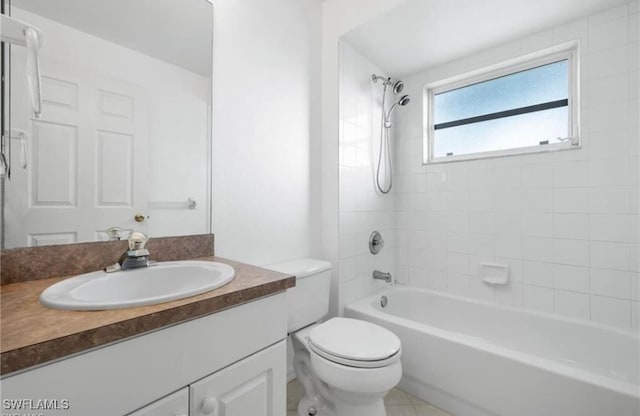 full bathroom with tile patterned flooring, tiled shower / bath, vanity, and toilet