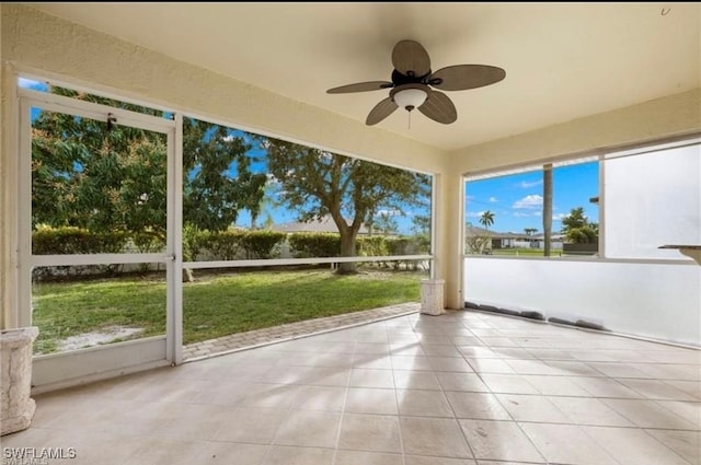 unfurnished sunroom with ceiling fan