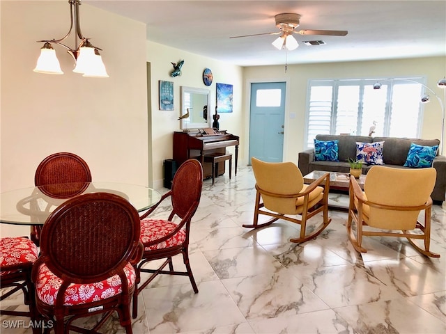 tiled living room featuring ceiling fan with notable chandelier